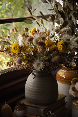 a large vase with a dried flower bouquet in it