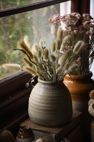 a large vase full of dried bunny tails